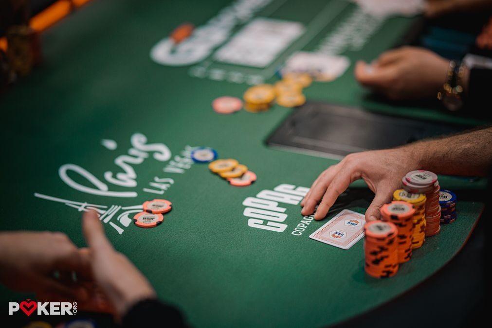 Игрок с картами и стеком фишек за столом на WSOP